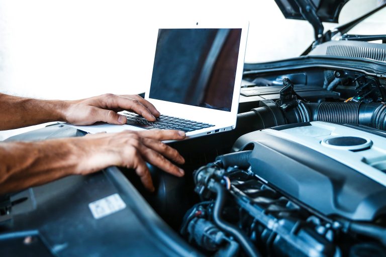 Mechanic using Garage Invoice Vehicle Management Software on his laptop